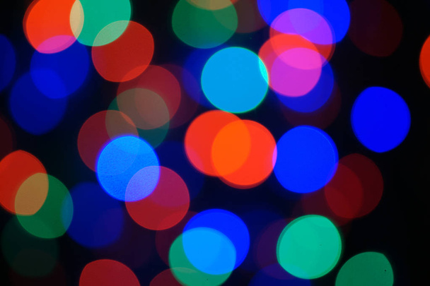 Vícebarevné modré vánoční věnce. Garland je rozmazaný. Mnoho velkých barevných kulatých světel. Plně rozostřená fotka. Rozmazané pozadí a popředí. Vánoční nálada. Nový rok a Vánoce se blíží. - Fotografie, Obrázek