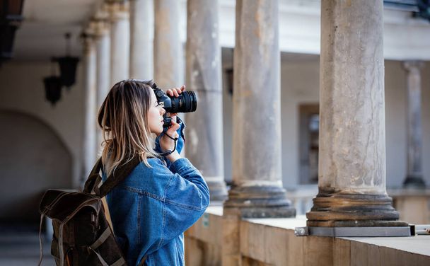 Young woman, professional photographer with camera in old castle - Foto, imagen