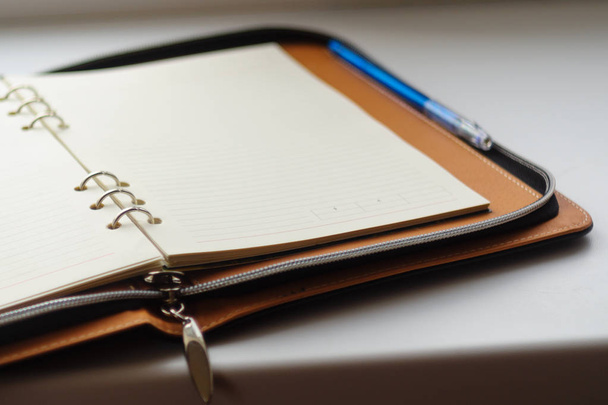 Αχρονολόγητο ημερολόγιο σε δαχτυλίδια με μπλε στυλό σε λευκό φόντο. - Φωτογραφία, εικόνα