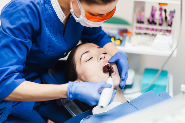 Молода жінка пацієнт на прийомі у стоматолога
 - Фото, зображення