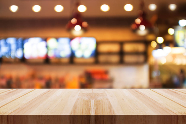 Empty wooden table top with blurred coffee shop or restaurant interior background. - Foto, Imagem