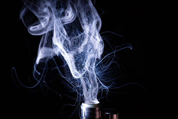 Vape smoke clouds isolated on black background. Hot vape liquid splash in vape coil. Nice aromatic cloud. Low light photo. Underexposed photo in a low key style.  - Photo, Image