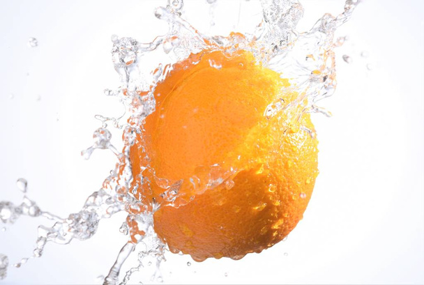 orange fruit with water splashing on;isolated white background - Fotoğraf, Görsel