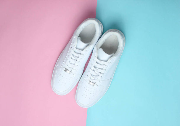 Fashionable white sneakers on a colored pastel background, minimalism, top view, creative layou - Fotografie, Obrázek