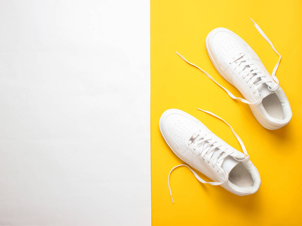 Μοντέρνα λευκά αθλητικά παπούτσια σε χρωματιστό παστέλ φόντο, μινιμαλισμό, κορυφή θέα, δημιουργική Layou - Φωτογραφία, εικόνα