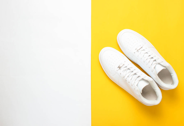 Zapatillas blancas de moda sobre un fondo pastel de colores, minimalismo, vista superior, torno creativo
 - Foto, imagen
