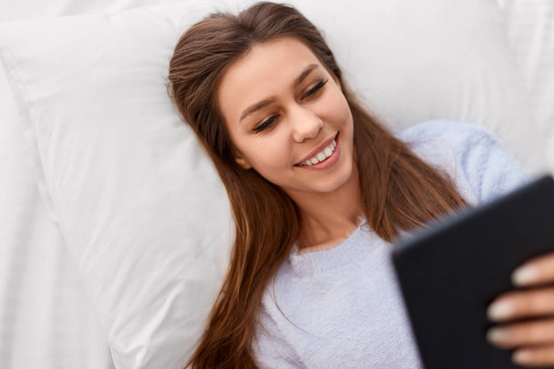 Smiling woman watching movies on tablet - Zdjęcie, obraz