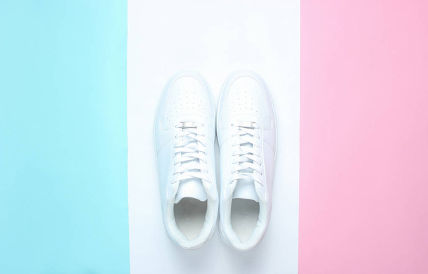 Bílé tenisky na barevném pastelových podkladech, minimalismus, vrcholové zobrazení, kreativní laje - Fotografie, Obrázek