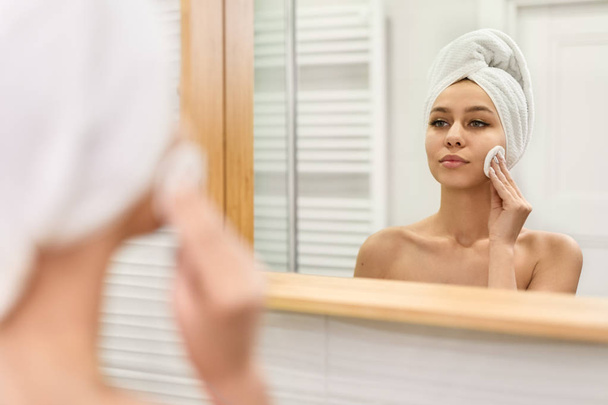 Woman cleaning skin near mirror - Foto, Imagem