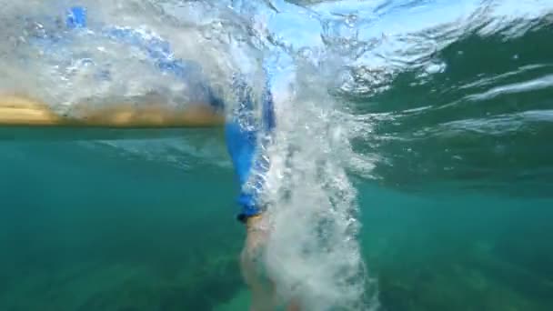 水中スローモーションクローズアップ極端なサーファーは、晴れた日に深い青い海で彼のサーフボードにパドリング。ロボスで夏休みを楽しむサーフィン愛好家。カナリア諸島のサーファーズパラダイス - 映像、動画