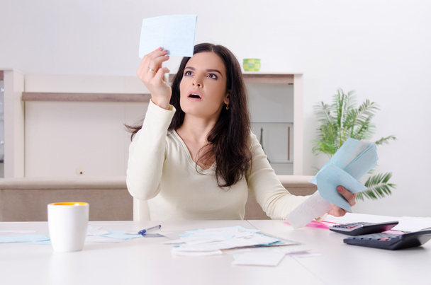 Young woman with receipts in budget planning concept  - Photo, Image