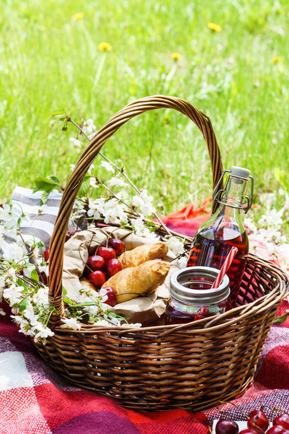 Picnic basket with food. Croissants, cherry berries and juice. - Valokuva, kuva