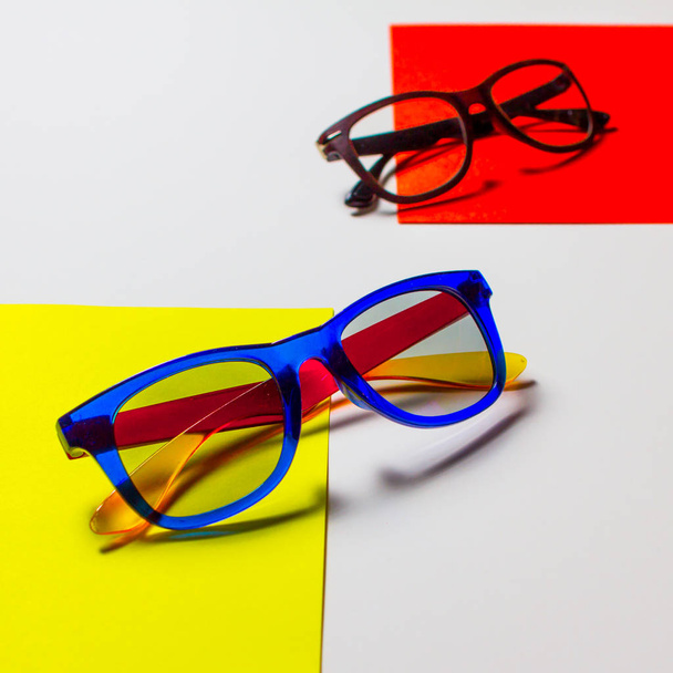 2019.04.05, Moscow, Russia. Abstract composition of sunglasses on the colorful cardboards and white background. Concept of summer vocations. - Foto, afbeelding