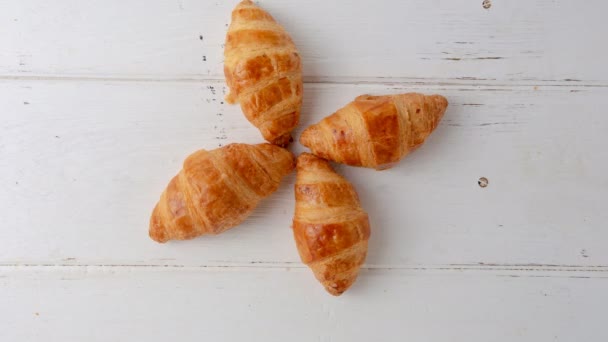 Zastavení čerstvě upečených croissantů na bílém dřevěném pozadí - Záběry, video