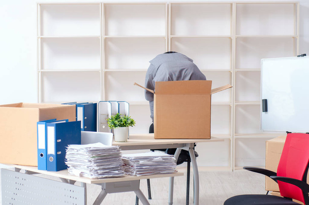 Молодий працівник з коробками в офісі
  - Фото, зображення
