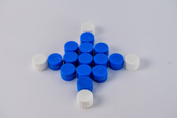 σχήμα φτιαγμένο με μπλε και άσπρα πλαστικά βύσματα, απομονωμένα σε λευκό φόντο. - Φωτογραφία, εικόνα