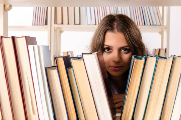 Młoda studentka przygotowująca się do egzaminów w bibliotece  - Zdjęcie, obraz