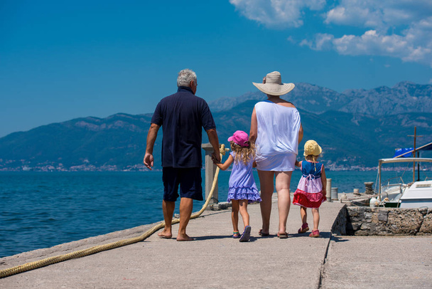 grandparents and granddaughters walking by the sea - Fotoğraf, Görsel