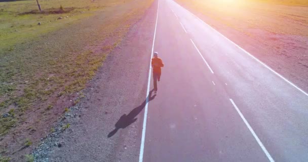 Vuelo de baja altitud frente al deportista en el camino perfecto de asfalto - Metraje, vídeo
