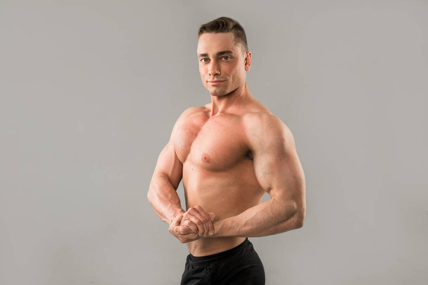 handsome man with muscles on gray background - Фото, зображення