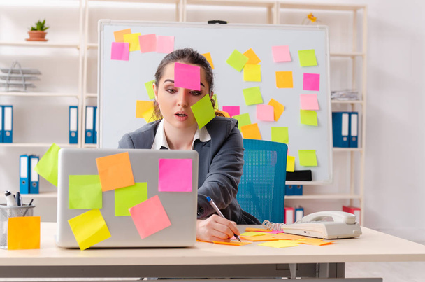 Young female employee in conflicting priorities concept  - Foto, imagen