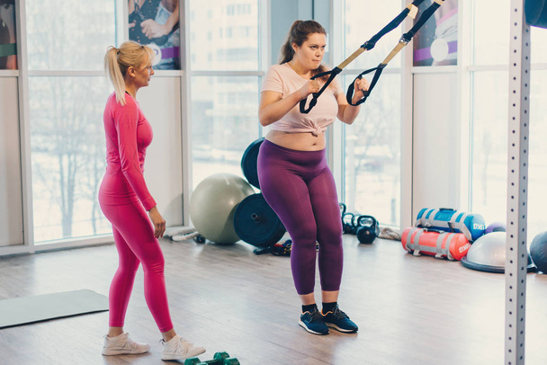 Female fitness trainer coaching her fat client - Фото, зображення