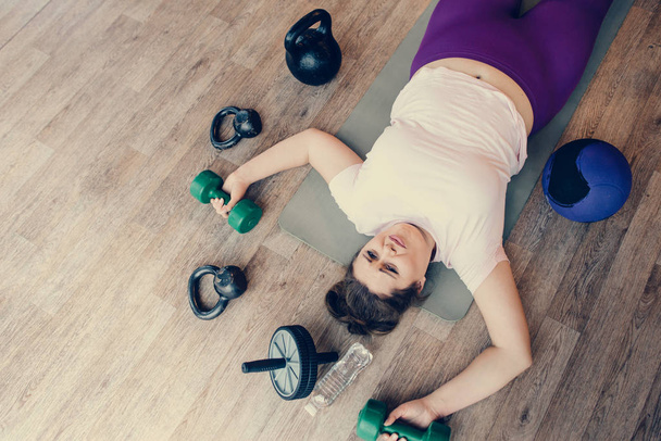 Tired fat woman lying on the floor in the gym - Fotografie, Obrázek
