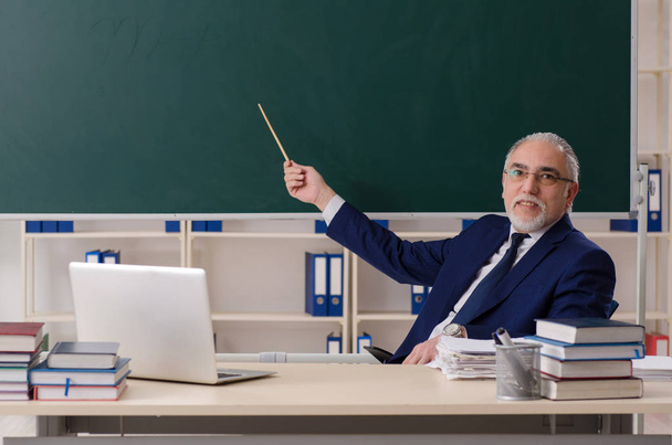 Aged male teacher in front of chalkboard  - Photo, Image