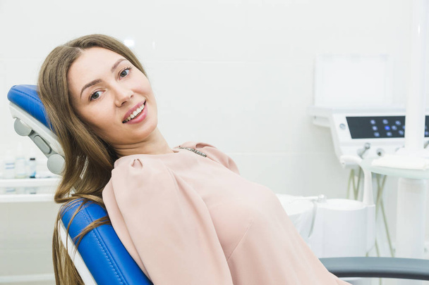 Dental clinic. Reception, examination of the patient. Teeth care. Young woman undergoes a dental examination by a dentist - Фото, зображення