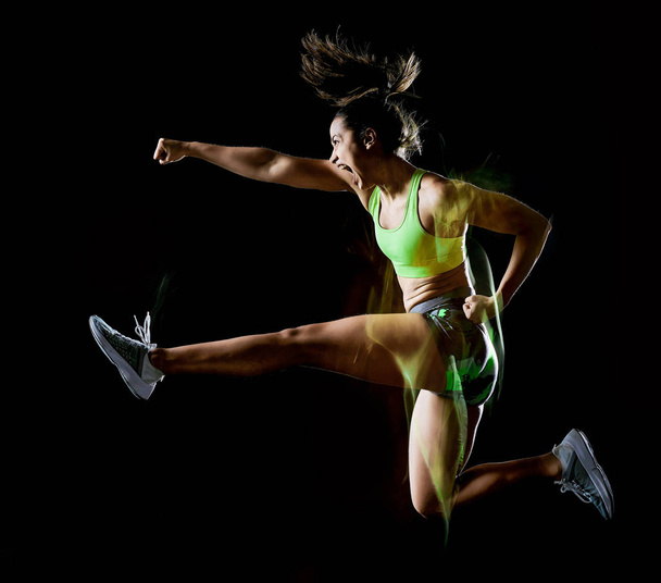 woman exercising fitness exercises isolated black background lightpainting effect - Foto, imagen