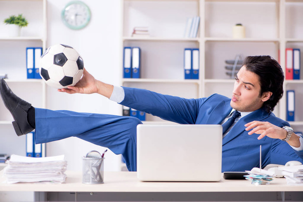 事務所にサッカー ボールを持つ若いハンサムな実業家  - 写真・画像