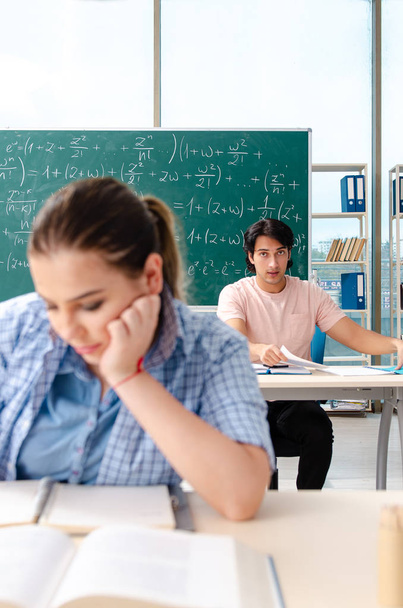 Молодые студенты сдавали экзамен по математике в классе
  - Фото, изображение