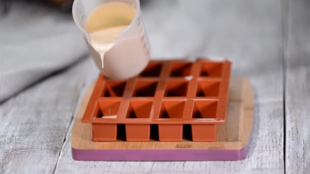 Pasticcere riempire uno stampo in silicone con una mousse al cioccolato. Fare dessert francese
. - Filmati, video