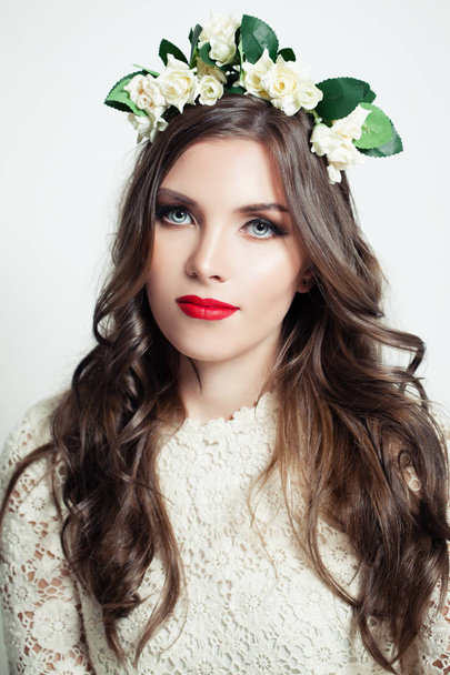 Belle fille en couronne de fleurs. Modèle femme avec lèvres teintées de rouge
  - Photo, image