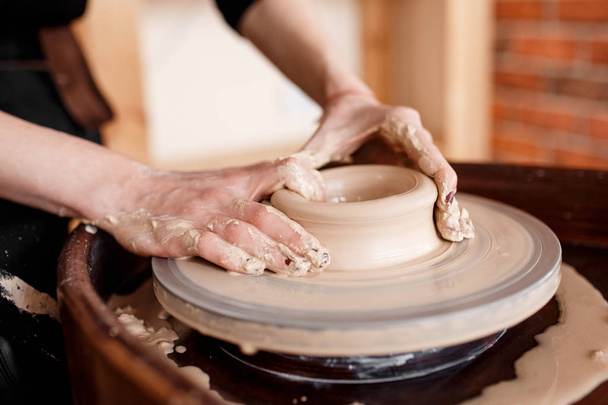 Hands sculpt new utensil on a pottery wheel - Фото, изображение