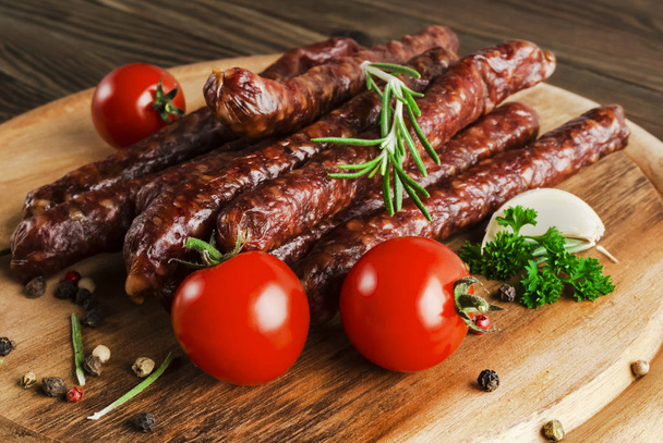 Smoked sausage with rosemary and peppercorns tomatoes and garlic - Foto, Bild
