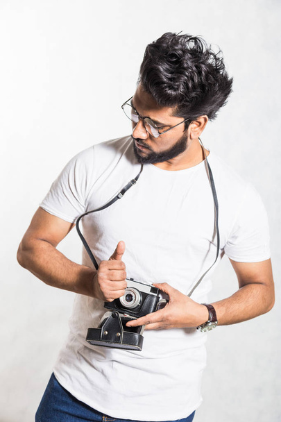 Portrait of a handsome young stylish man with beard taking photo on a vintage camera. - Fotoğraf, Görsel