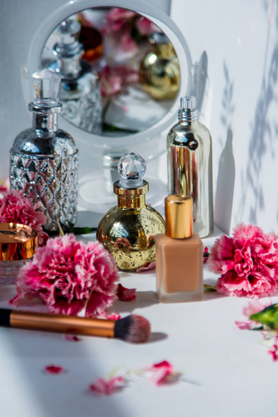 Parfum, funderings crème, penseel en reflectie met Dianthus FL - Foto, afbeelding
