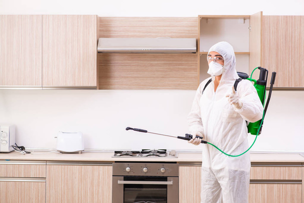Professional contractor doing pest control at kitchen - Фото, зображення