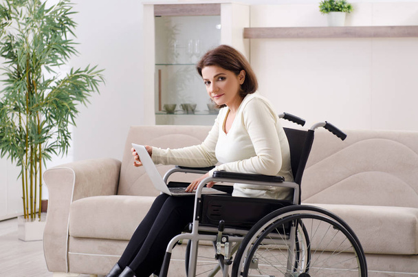 mujer en silla de ruedas en casa  - Foto, imagen