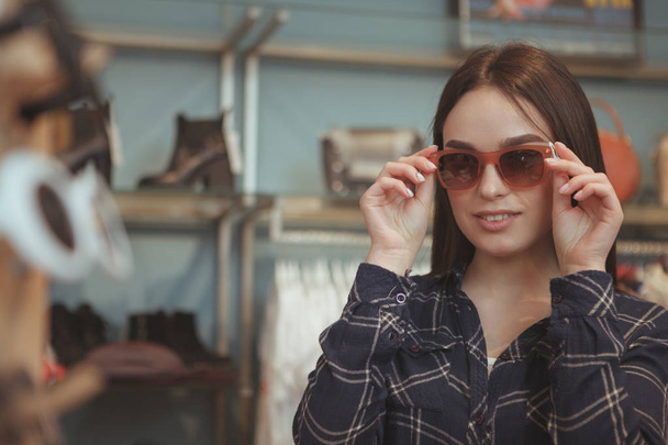 Очаровательная молодая женщина покупает очки
 - Фото, изображение