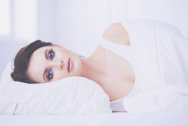 Young beautiful woman lying in bed. - Foto, afbeelding