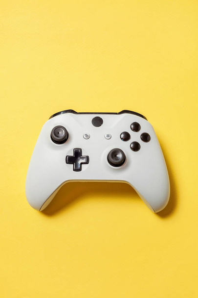 Biały joystick na żółtym tle. Konkurs gier komputerowych gry kontroli konfrontacji koncepcja - Zdjęcie, obraz