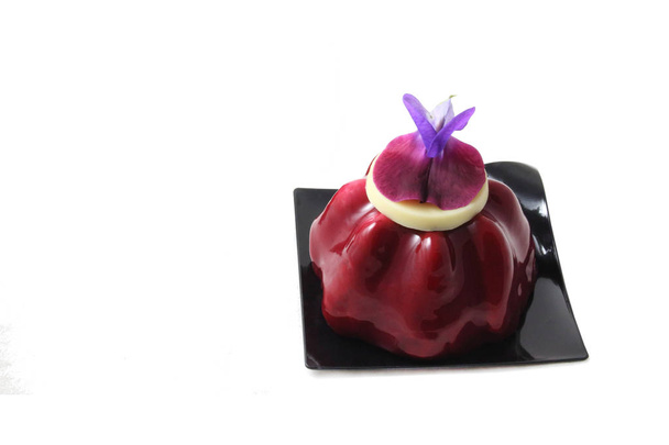 Czerwony deser owocowy z jadalnym purpurowym kwiatem grochu na białym - Zdjęcie, obraz