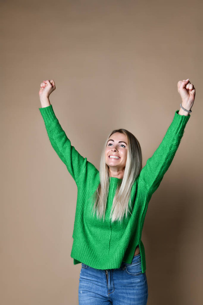 Portrait of young caucasian, sweet, successful woman celebrating victory with raised fists, smiling - Photo, Image