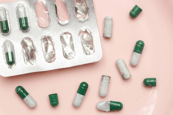 Zöld és fehér kapszulát tablettát egy buborékfólia csomag, felülnézet rózsaszín - Fotó, kép