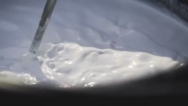 Makro záběr míchání bílé barvy vrtákem v kbelíku - Záběry, video