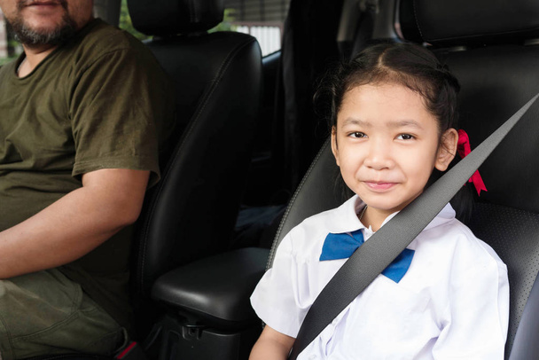 女の子は車に座り、安全のためにベルトを締める - 写真・画像