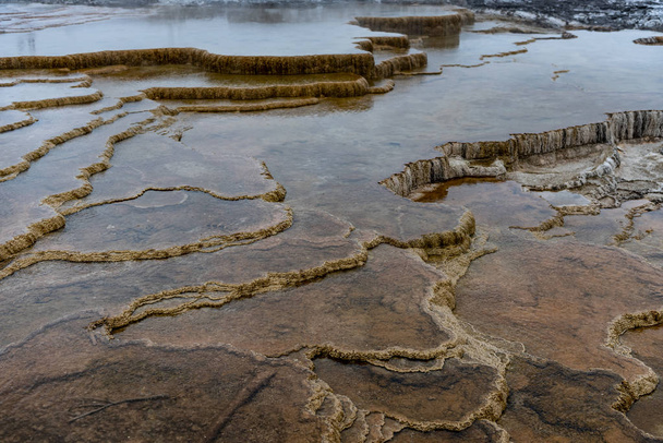 Capas de roca volcánica en el agua
 - Foto, imagen