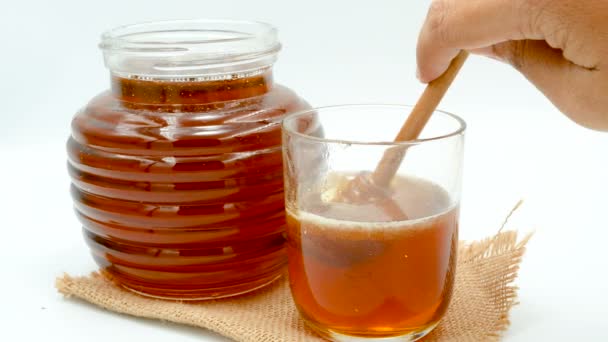 Close-up honing laten vallen met houten. Dipper in een glazen plaats op de zak. - Video